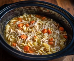 Egg noodles added to broth for chicken noodle soup in slow cooker