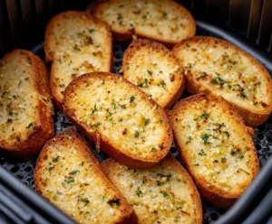 Garlic bread slices placed in air fryer basket ready to cook