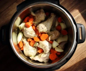 Chicken placed over sautéed vegetables in pressure cooker