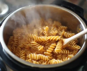 Cooked pasta stirred with sauce after pressure release