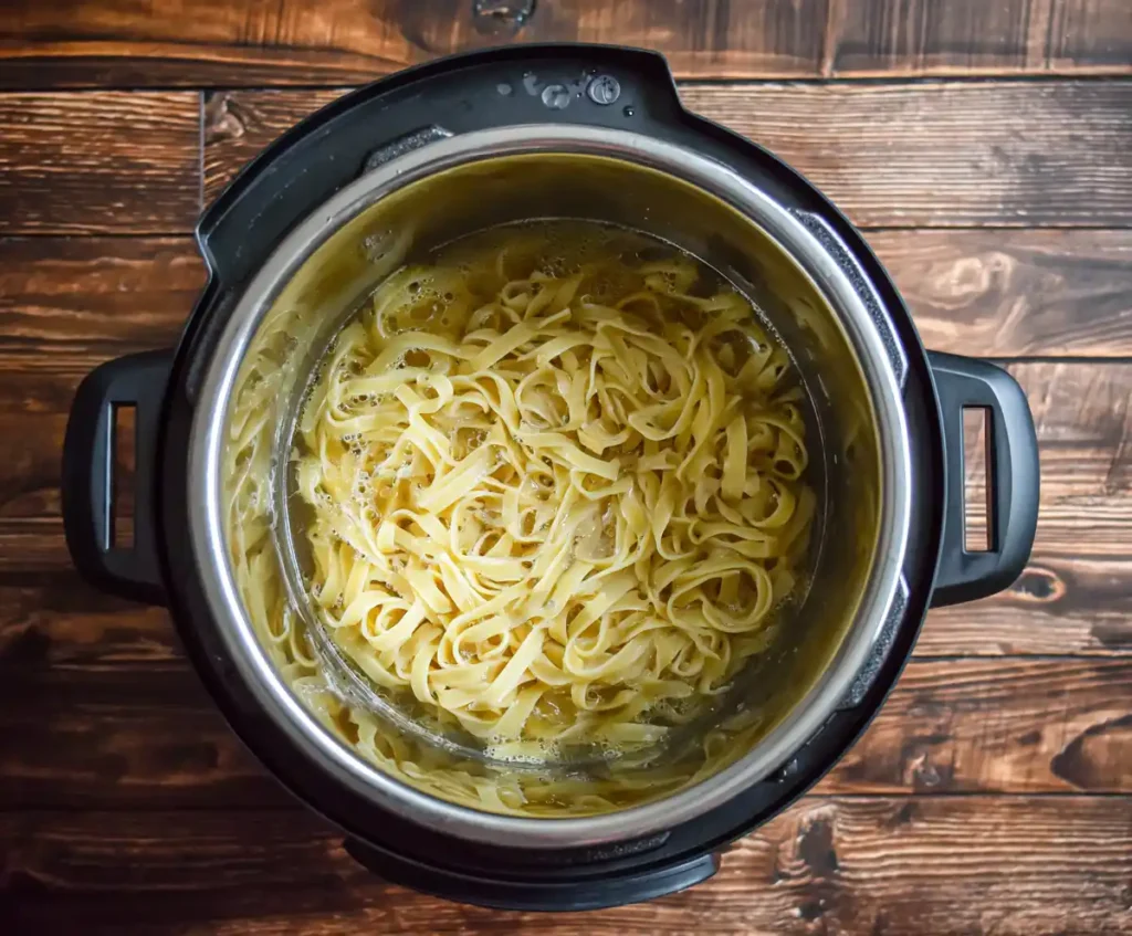 Fettuccine pasta and broth in Instant Pot before pressure cooking