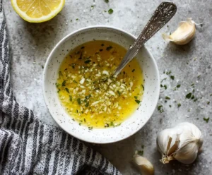 Greek dressing with olive oil, lemon, oregano, and garlic in a bowl