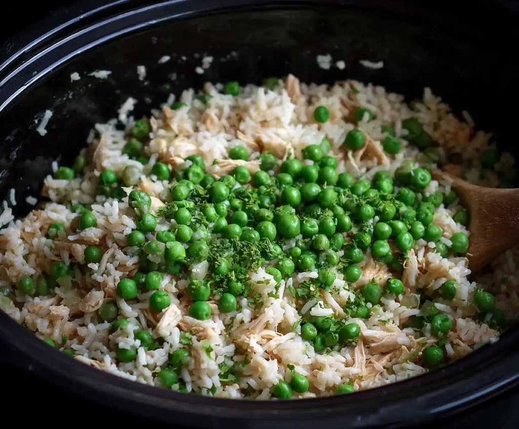Chicken broth poured over rice, chicken, and vegetables in slow cooker