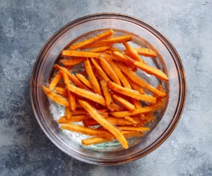Sweet potato fries soaking in water before air frying